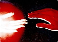 two hands touching each other over a red object