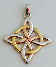 a gold and silver pendant with an intricate design