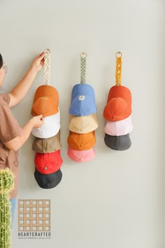 a woman is hanging hats on the wall