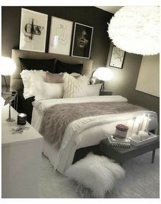 a white bed sitting next to two lamps and pictures on the wall