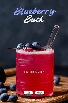 blueberry buck cocktail in a glass with strawberries on the side and text overlay that reads, blueberry buck fruchti & spicy