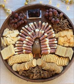 a turkey shaped platter with crackers, cheeses and other snacks on it