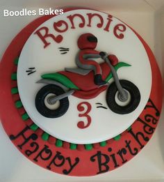 a red and white birthday cake with a motorbike on it's side