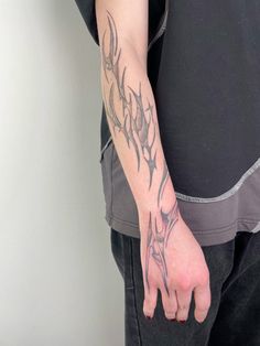 a man with a tattoo on his arm and hand holding something in the other hand