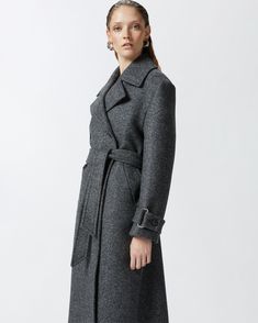 Women's long double-breasted coat made from yarn-dyed wool-blend twill cloth. The silhouette—which includes a lapel collar, long sleeves with cuff tab and matching-fabric waist belt—is inspired by the classic trench coat. Slanted side pockets and double-breasted button fastening. Chic Wool Coat With Belted Cuffs And Lapel Collar, Formal Long Coat With Belted Cuffs, Chic Wool Coat With Belted Cuffs And Notch Lapel, Luxury Wool Coat With Belted Cuffs For Office, Formal Wool Coat With Belted Cuffs And Lapel Collar, Office Wool Coat With Notch Lapel And Belted Cuffs, Timeless Outerwear With Belted Cuffs For Work, Spring Business Wool Coat With Belted Cuffs, Formal Long Wool Coat With Belted Cuffs