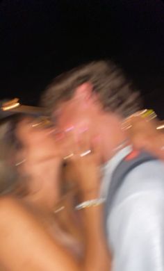 blurry photograph of two people talking on their cell phones in the city at night