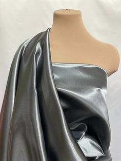 a mannequin wearing a silver dress with one shoulder draped over it and an asymmetrical top