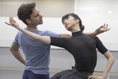 a man and woman in ballet clothes standing next to each other