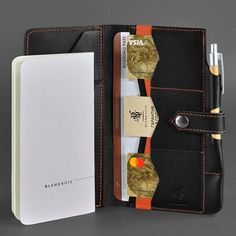 an open wallet with a notepad and pen in it