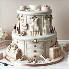 a wedding cake is decorated with white and gold accessories, including shoes, purses, dresses, and jewelry