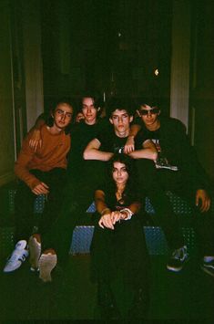 a group of young men sitting next to each other in front of a window at night