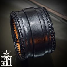 "This Black leather cuff is 2\" wide and hand dyed in a sleek black finish. It is hand braided along the edges with kangaroo lace and also features a hand tooled beveled ridge. A 3/4\" strap is woven through center and closes with leather covered snaps! Custom sized for your wrist! -2\" wide -Vegetable tanned leather -fully lined -Handmade in New York Thanks! Freddie" Formal Black Leather Braided Bracelets, Adjustable Black Hand Tooled Bracelet, Black Leather Cuff Bracelet For Formal Occasions, Handmade Black Cuff Bracelet, Handmade Black Leather Cuff Bracelet, Adjustable Leather Cuff Bracelet Hand-stitched, Leather Cuff Bracelet For Formal Occasions, Adjustable Hand-stitched Leather Cuff Bracelet, Formal Leather Cuff Bracelet