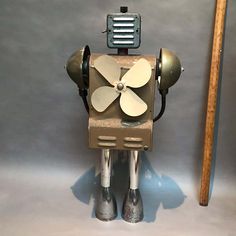 an old fashioned robot is standing next to a baseball bat