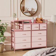 a pink dresser sitting next to a mirror