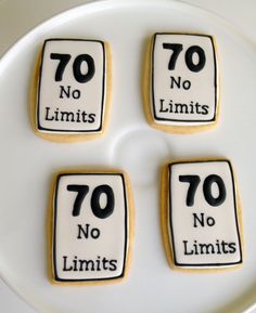 four cookies with the words 70 no limits and seventy no limits are on a plate