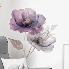 two purple flowers on a white wall next to a gray chair