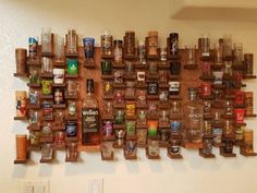 a wooden shelf filled with lots of different types of liquor bottles on top of it