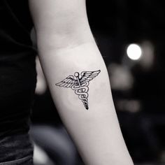 a woman's arm with a medical symbol tattoo on the left side of her arm