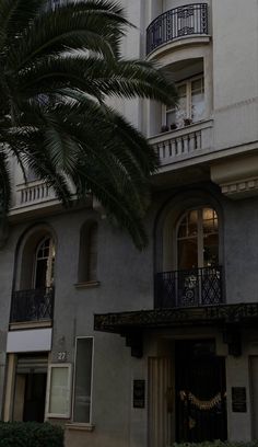 an apartment building with balconies and palm trees