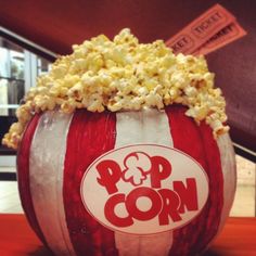 a large red and white striped popcorn bucket with the word pop corn written on it