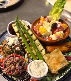 a plate with many different types of food on it, including asparagus and other vegetables