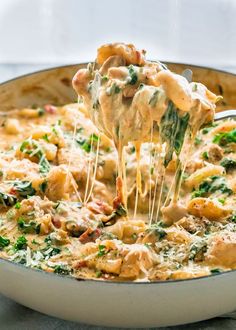 spinach lasagna casserole being lifted with a spatula from a skillet