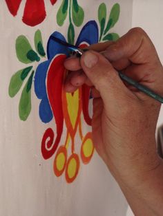 a person is drawing on a piece of paper with colored pencils and watercolor paints