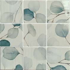 several tiles with leaves painted on them in shades of blue and green, all arranged together