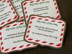 four elf joke cards sitting on top of a wooden table