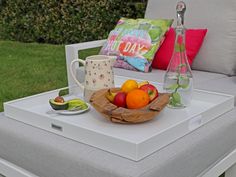 a bowl of fruit sitting on top of a white table