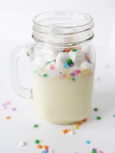 a mason jar filled with white chocolate and sprinkles