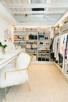 a white chair sitting in front of a closet filled with clothes and other items on shelves