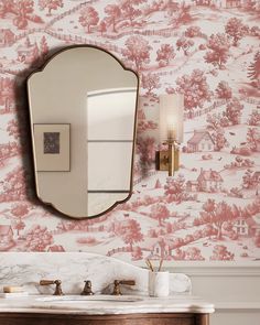 a bathroom sink with a mirror above it and a wallpapered background behind it