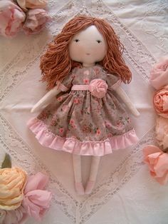 a doll is laying on a table with pink flowers and lace around it's edges