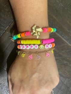 "~Winnie~ This four piece bracelet set is super colorful and super fun PLUS you can customize one of the bracelets for personalization. The set includes: - the matte gold, windmill bracelet with colorful, rubber, heishi cut beads in vibrant colors with gold toned, heishi spacers. This bracelet is size adjustable from 5.5\"-7\" long. - the rubber, heishi bead bracelet with vibrant pink, green, white, yellow and orange sections with gold toned, heishi spacers separating the colors. All are strung on clear, stretch cord. This bracelet is roughly 7\" around, unstretched.  - the \"HappyAF\" bracelet. This bracelet spells out \"HappyAF\" with a yellow smiley face bead separating the words. The rest of the bracelet is made up of rubber, heishi cut beads in various vibrant colors with the tie knot Heishi Bead Bracelet, Rainbow Braids, Star And Moon Necklace, Yellow Smiley Face, Silk Bag, Necklace Extender, Neon Rainbow, Rainbow Bracelet, Heart Pendant Gold