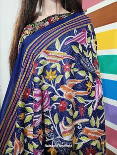 This Nakshi Kantha Stitch Dupatta is done by a Skilled  Kantha Artist from West Bengal.  Kantha is a running-stitch style from West Bengal, where multi-color and multi-thread with elaborate designs are vividly embroidered onto the textile to give it a textured aesthetic. This Floral Dupatta is hand embroidered & and comprises the vibrant colors & and design motif of florals and birds. Dupatta Length : 2.5 meters Dupatta Width : 44 Inches Design : Nakshi Kantha Hand Embroidery Fabric : Bangalore -- Silk Mark Certified. Color :  Blue, Brown and Magenta Washing : Dry Clean Get this exclusive Hand Embroidered Kantha Saree online at Rainbow Boutique - The best online store for pure silk saree, tussar silk saree. Multicolor Embroidered Shawl With Traditional Drape, Multicolor Floral Embroidered Blouse Piece For Navratri, Traditional Multicolor Embroidered Choli, Blue Bohemian Blouse Piece With Zari Work, Embroidered Multicolor Blouse Piece For Transitional Season, Transitional Multicolor Embroidered Blouse Piece, Diwali Multicolor Embroidered Shawl, Blue Bohemian Blouse Piece With Dupatta, Bohemian Blue Blouse Piece With Dupatta