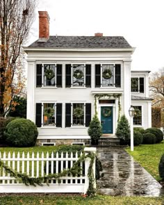 a white house with wreaths on the front door