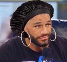 a man wearing large hoop earrings and a turban