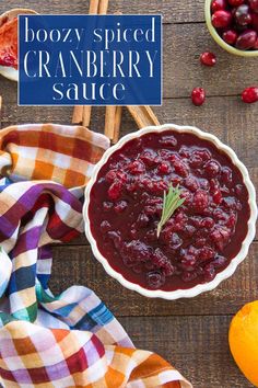 cranberry sauce in a bowl on top of a wooden table next to oranges