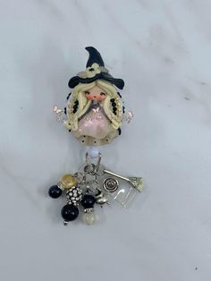 a glass figurine with a hat on it's head and various charms around it