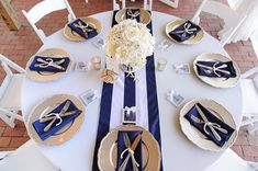 the table is set with blue and white napkins, silverware, and flowers