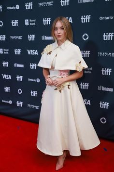 a woman standing on top of a red carpet