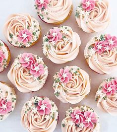 many cupcakes with pink frosting and flowers on them are arranged in a circle