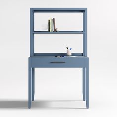 a blue book shelf with books on it and a cup sitting on top of it