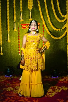 a woman dressed in yellow poses for the camera