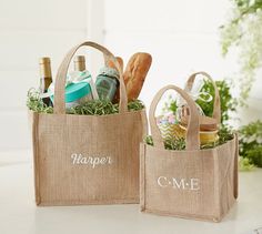 two jute bags filled with personalized items on top of a white countertop