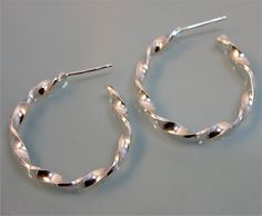 "These Spiral Twist earrings are fabricated from sheet sterling silver and handmade from start to finish. They are the perfect size hoop for everyday wear. 1\" diameter, apporx 3mm width and 1mm\" thick silver. Earrings also have a sterling silver post and back. For an alternative look, these can also be fabricated with a satin finish. All items are presented in a 100% recycled paper box with a paper raffia bow. Thank you for looking at my shop. http://www.etsy.com/shop/tinysparklestudio For LEA Silver Spiral Hoop Earrings For Everyday, Everyday Silver Spiral Hoop Earrings, Everyday Spiral Silver Hoop Earrings, Spiral Sterling Silver Hoop Earrings, Twist Earrings, Recycled Sterling Silver, Paper Box, Recycled Paper, Open Back