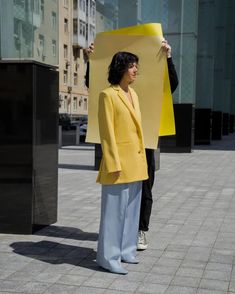 a woman holding up a yellow piece of paper