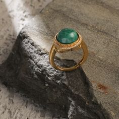 Description Inspired by the beautifully patterned Malachite gemstone, the earliest ore of copper, Tamra is eccentric, contemporary, and distinctively classy. Handcrafted on 925 hallmark silver and gold finish. This collection is curated for everyday luxury. This finger ring features a round malachite charm at the center encircled with a single line of CZ stones to add extra glam. Striking ring to style with Paksha's unmatched delicate jewelry. Product Information Materials used: 925 Silver with Elegant Gold Emerald Ring With Tarnish Resistance, Elegant Emerald Ring Gift Tarnish Resistant, Luxury Gold Emerald Ring With Gemstone Accents, Elegant Yellow Gold Rings With Natural Stones, Luxury Rings With Natural Stones, Elegant Yellow Gold Ring With Natural Stones, Elegant Emerald Rings With Natural Stones, Elegant Open Ring With Natural Stones, Elegant Jewelry With Natural Stones In Open Ring Shape