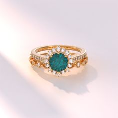 a ring with a green stone surrounded by diamonds